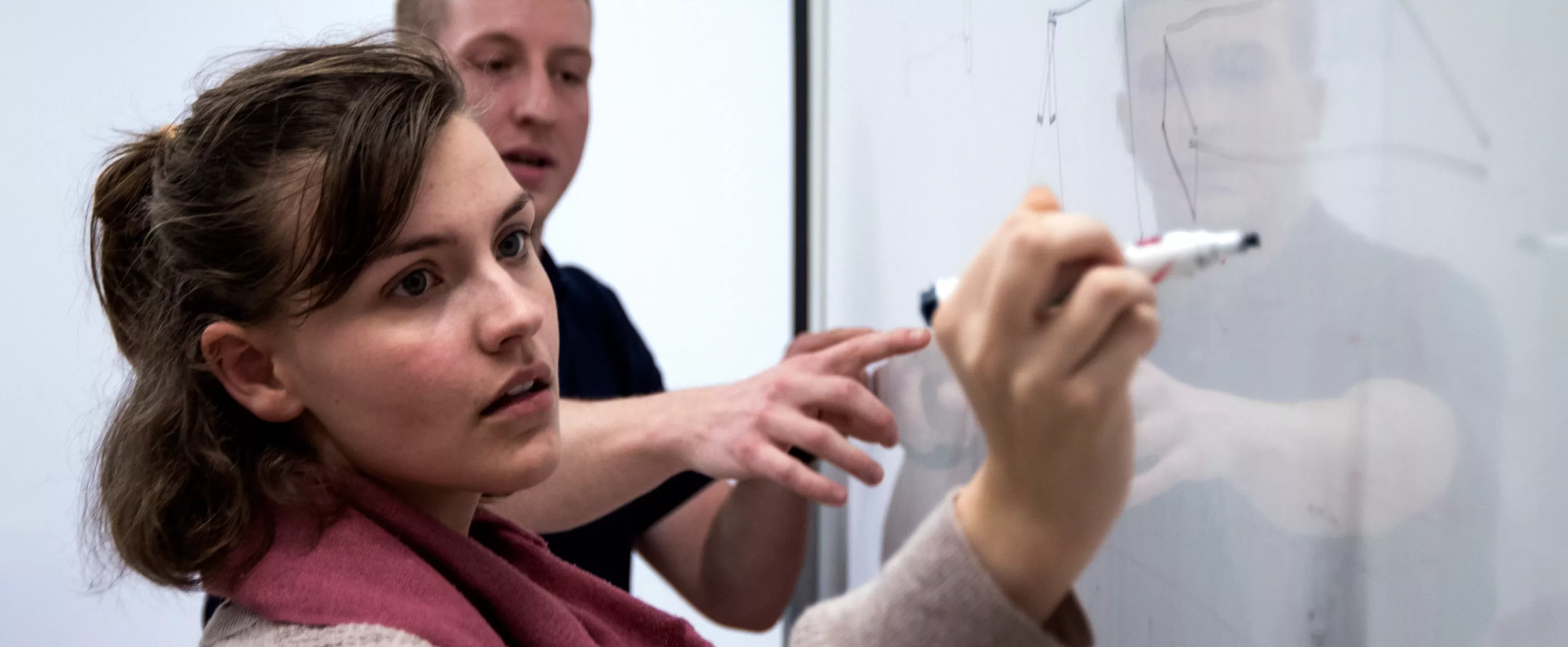 Student writes on a white board