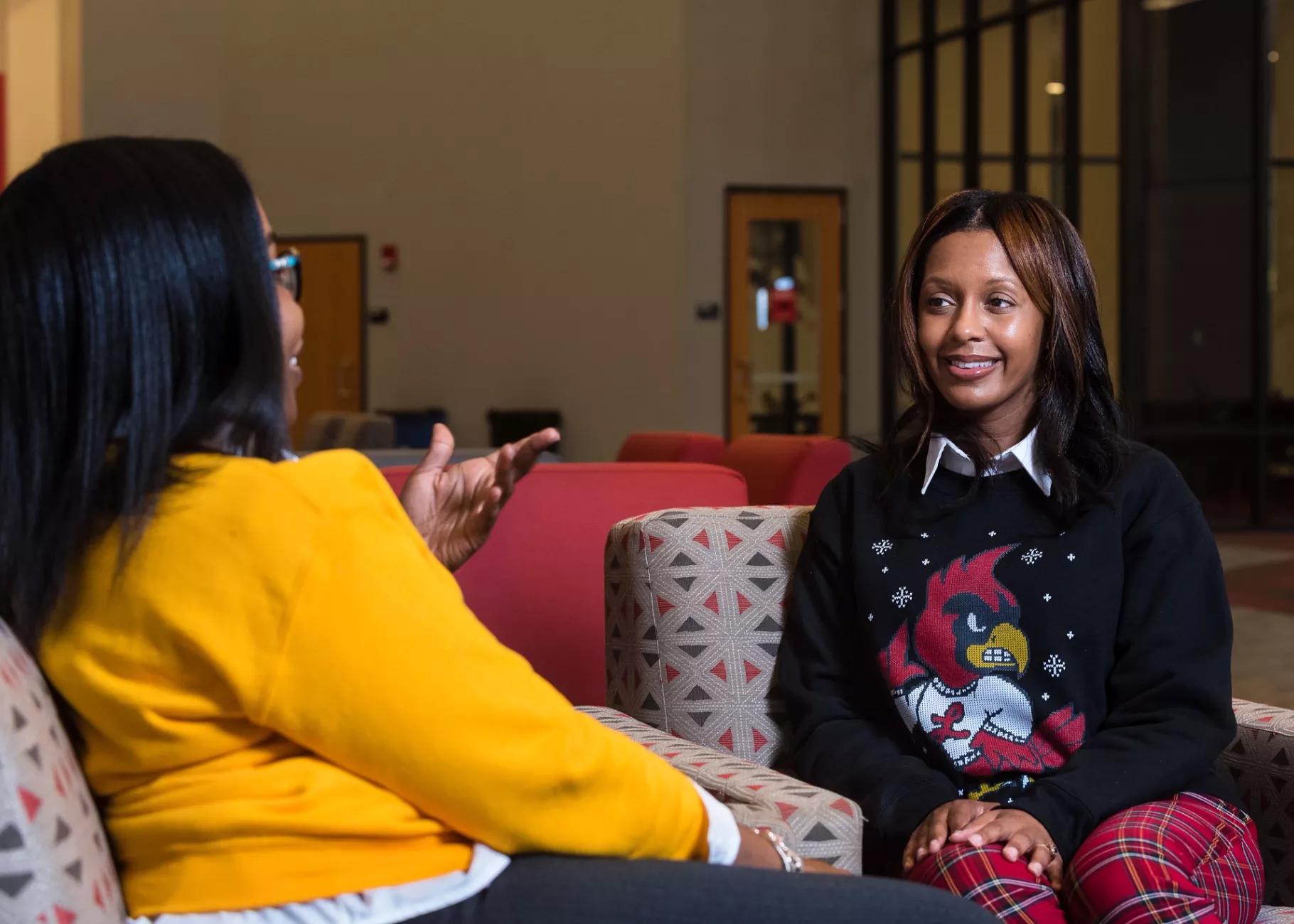 Two staff conversing while sitting in chairs in the SAC.