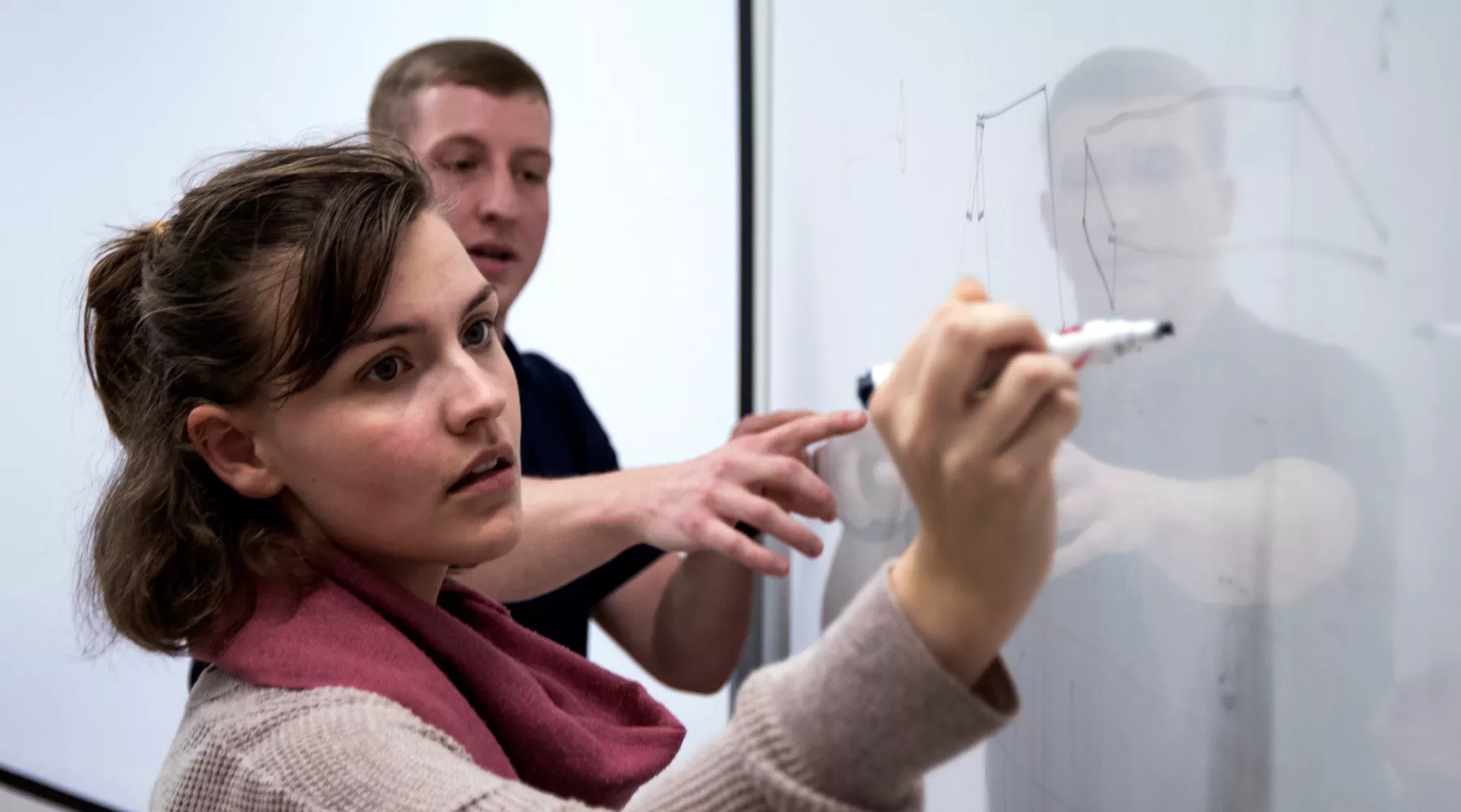 Student writes on a white board