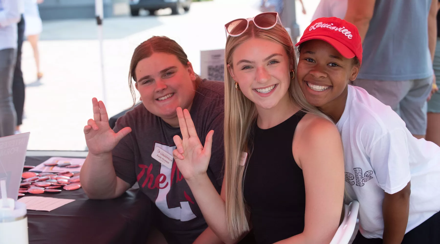 Three students smiling at the camera during Homecoming
