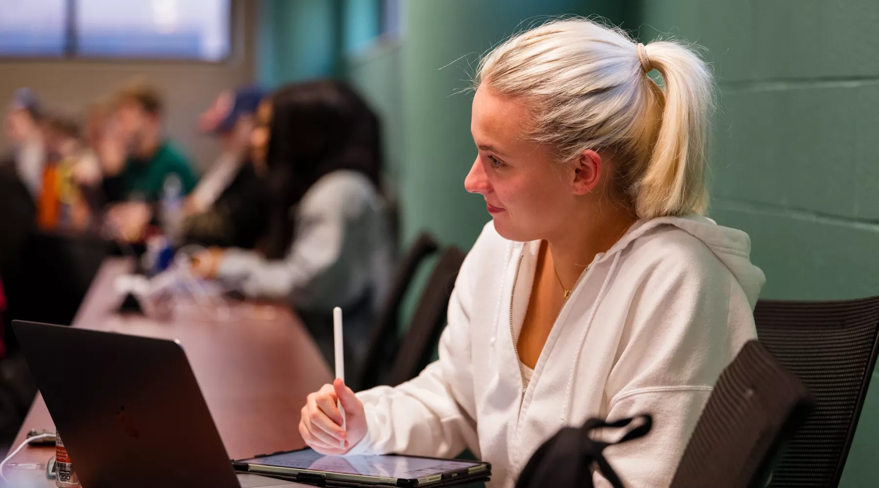 Students in a nursing lecture listening and taking notes.