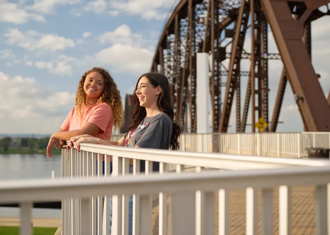 Two students looking at the skyline on the bridge.