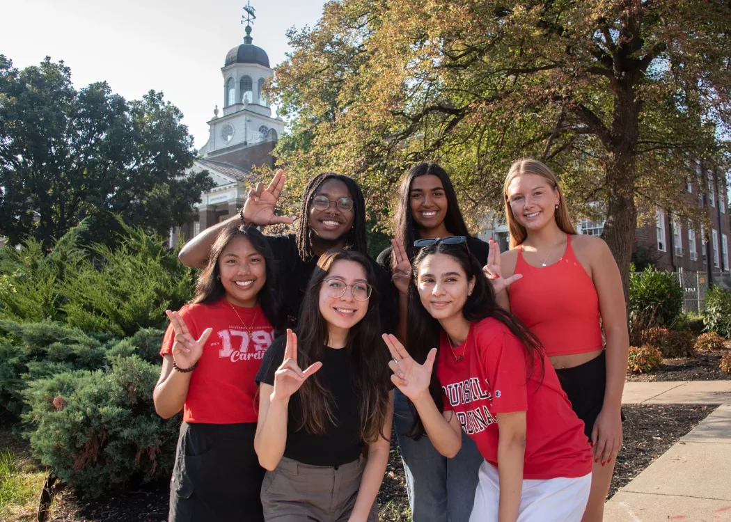 UofL Students posing and throwing up an "L"