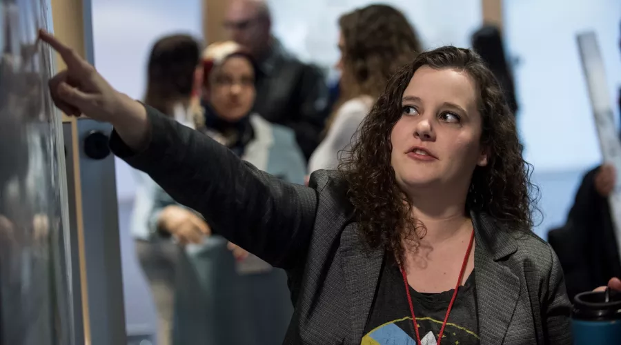 Student points to a board at the Graduate Research Conference.