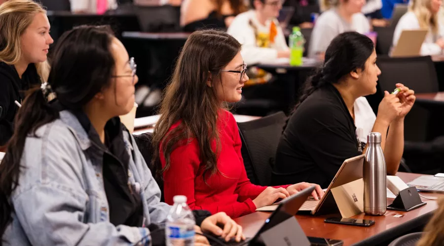 Students in a nursing lecture listening and taking notes.